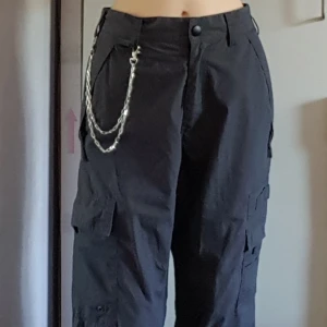  - Gråa cargobyxor med fickor och hängen. Går att ta av nederdelen av byxan med dragkedjor. Har några små, knappt synliga fläckar på ena låret och är lite slitna vid fötterna på snörena samt har två igensydda hål (se sista bilden). Storlek S men tycker de är lite stora i storlek och mer som kdnske ca S/M. Fraktkostnaden blir 72kr.