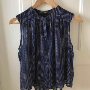  - Söt marinblå blus med vita prickar. Aldrig använd med prislapp kvar. Riktigt fin till fest eller vardag!