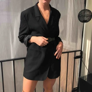  - Lång svart kavaj som passar perfekt att använda som klänning, bälte ingår ej. Skulle säga att storleken är en S-M beroende på hur man vill att den ska sitta.