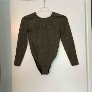  - Guld body med djup rygg. Snyggt glittrig, tunt material