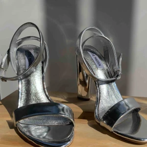  - Silver färgade Steve Madden sandaletter i strl 39.  Köparen står för frakten, kan avhämtas i Stockholm.
