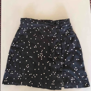  - Svart kjol med vita prickar från h&m. Storlek XS men passar även S. Kjolen har knappar men en liten slits längst ner. 