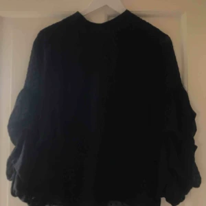  - En fin svart prickig blus med volang ärmar