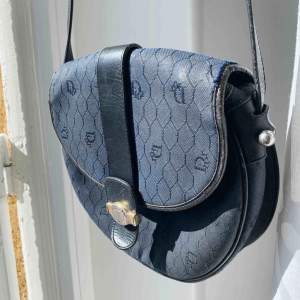 vintage dior axelremsväska i modell Honeycomb Canvas Circular Messenger Bag. Med klassiskt Dior mönster i mörkblå.