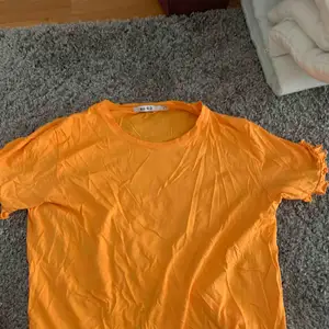 Snygg orange tröja från NA-KD, med typ ”volanger” på armkanterna. Knappt använd, endast ett fåtal gånger. Säljer för att jag inte använder den längre🥰  Storlek S! Frakt står köparen för😊
