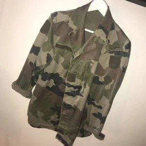  - Vårjacka i militär mönster! Ingen lapp i men ska vara en L. Använd fåtal gånger! Kan posta men då står köparen för frakten!