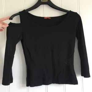  - Semitransparenr topp linne i svart med en öppen axel, ser coolt ut. 3/4 ärmel. Bra skick.