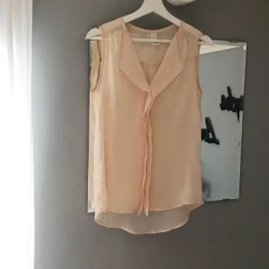  - Jätte fin blus i en beige/persikafärgad ton. Tunnt material och något genomskinligt. Aldrig använd. Hel och ren. Fraktas mot kostnad.