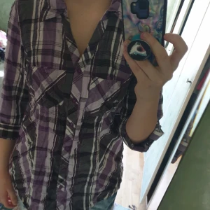  - Lila skjorta, designad utan översta knapparna och insydd i kanterna. Frakt inte inkluderad.