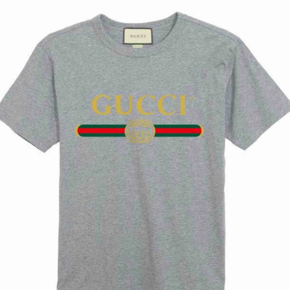 Gucci  Fabric:100 Percent Cotton   Color:Grey    Sleeve:Half Sleeve   Pattern:Printed   Neck Shape:Round   Fit:Regular Fit. T-shirts.