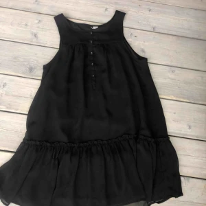  - Svart klänning med knappar på. Mjukt och bekvämt tyg.