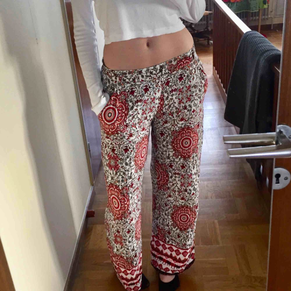 Lösa ”flowy” byxor i ett detaljerat rött mönster. I storlek 38 eller L men dom är mindre i midjan. Rätt långa då jag är 178cm och de är perfekt i längden på mig! Möts upp i Stockholm, skriv om ni har frågor eller vill ha fler bilder! :). Jeans & Byxor.