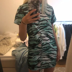 Zebramönstrad tshirtklänning strl 34 - Turkosblå zebramönstrad tshirtklänning från prettylittlething. Knappt använd! Frakt tillkommer