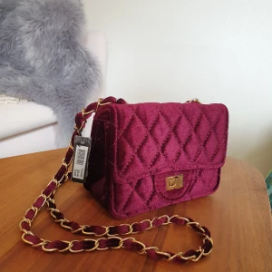 Vinröd axelremsväska - Vinröd väska från Montini i velvet-material. Oanvänd med lappen kvar. Mått: 17 x 13 x 7 🌟 nypris 298 kr. Finns vid Gärdet, köparen står annars för frakt. 