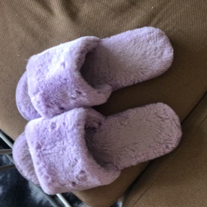 Tofflor  - Lila/ljuslila Gosiga innetofflor ! Jag har storlek 36 som ni ser på bilden är dom lite för långa för mig :) står 36/37 under tofflorna . Hela och fina! 