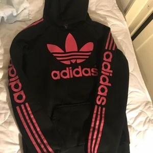 Adidas - En svart rosa adidas huvtröja som är varm och mysig. Säljs bara i Helsingborg