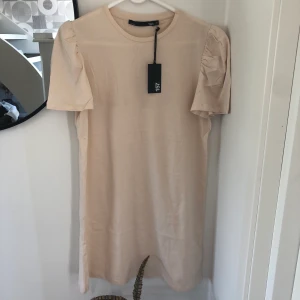 Klänning  - NY beige superskön klänning med puffärm från Lager 157, storlek M. 