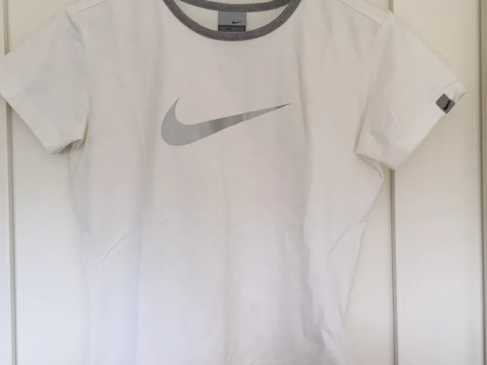 Vintage Nike Athletic T-shirt med grå och silvriga detaljer i stretchigt vitt tyg (90% bomull). T-shirts.