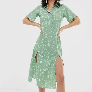 Prickig skjortklänning  - Säljer denna helt oanvända skjortklänningen från asos. Prislappen sitter kvar! Den är prickig och har fyra knappar upptill och två slittar nertill ❤