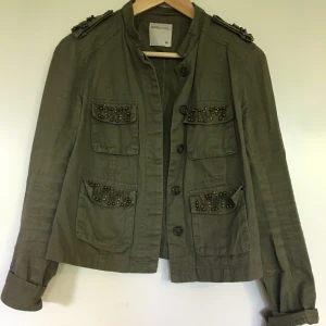 Jacka  - Kort jacka i militärgrön med detaljer. Köpt i spannien på Berskha. 
