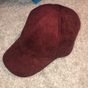Keps - Vinröd keps i mocka material