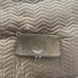 Zadig Voltaire väska - Zadig Voltaire väska i khaki färg. Dustbag medkommer och en till kedja som är längre. Det ser ut som att det är olika färger på mockan men de ser inte ut så lika mycket i verkligheten☺️