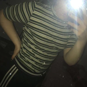 Grön randig tröja, storlek M - Armbåges kort tröja med halv polo vid halsen, grön, vit och guld randig, låter kanske inte så fint men den är riktigt fin på, storlek M men den är stretchig:)