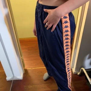 Kappa trackpants - Vintage kappa trackpants, dragkedja längs hela benen. Är i strl L och är oversize så passar allt från S-L beroende på passform💕