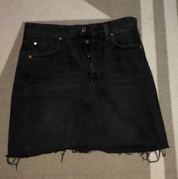 En svart/ grå jeans kjol från H&M med lite slitningar längst ner. Storlek 36 och passar mig som vanligtvis  har S/M. . Kjolar.