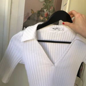 Ribbad topp från NAKD  - Vit ribbad topp från NAKD, med v-ringning & krage. Superbra skick! Bara använd 1 gång. Kontakta mig för fler bilder eller för att lägga egna bud. 💘