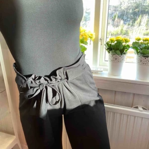  - Ett par mjuka kostymbyxor med knytning i midjan