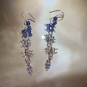 Örhängen - Handgjorda örhängen med olika blåa glaspärlor, krokarna är av silvertråd🌟 (frakten är inräknad i priset)❣️