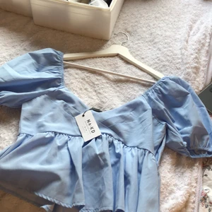 Jättefin topp från Nakd  - Jättefin ljusblå topp från Nakd. Aldrig använd, prislappen sitter kvar. Storlek 40 men sitter som 38. Fina volanger på ärmarna och nedanför magen. 