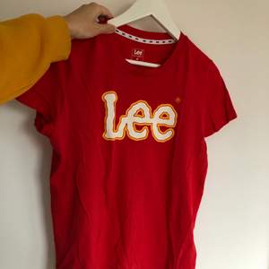 Röd Lee T-shirt med vit/gul text i storlek M (normal passform). Säljer för 25kr + frakt! ♻️✨