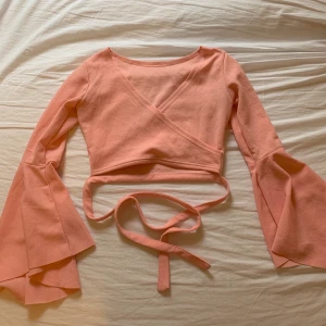 Wraparound tröja - Wrap around tröja med vida ärmar i supersöt babyrosa färg. Band som knyts runt midjan 🌷 superbra skick!