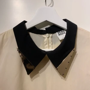 Beiget linne - M - Beiget linne från Vero Moda i storlek M med guldig detalj uppe. Längre baktill. Dragkedja bak. 50kr+ frakt.