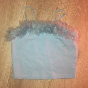 Topp furr Dollskill - Helt oanvänd croptopp från Dollskill i blått med ”päls” längst med urringningen. 