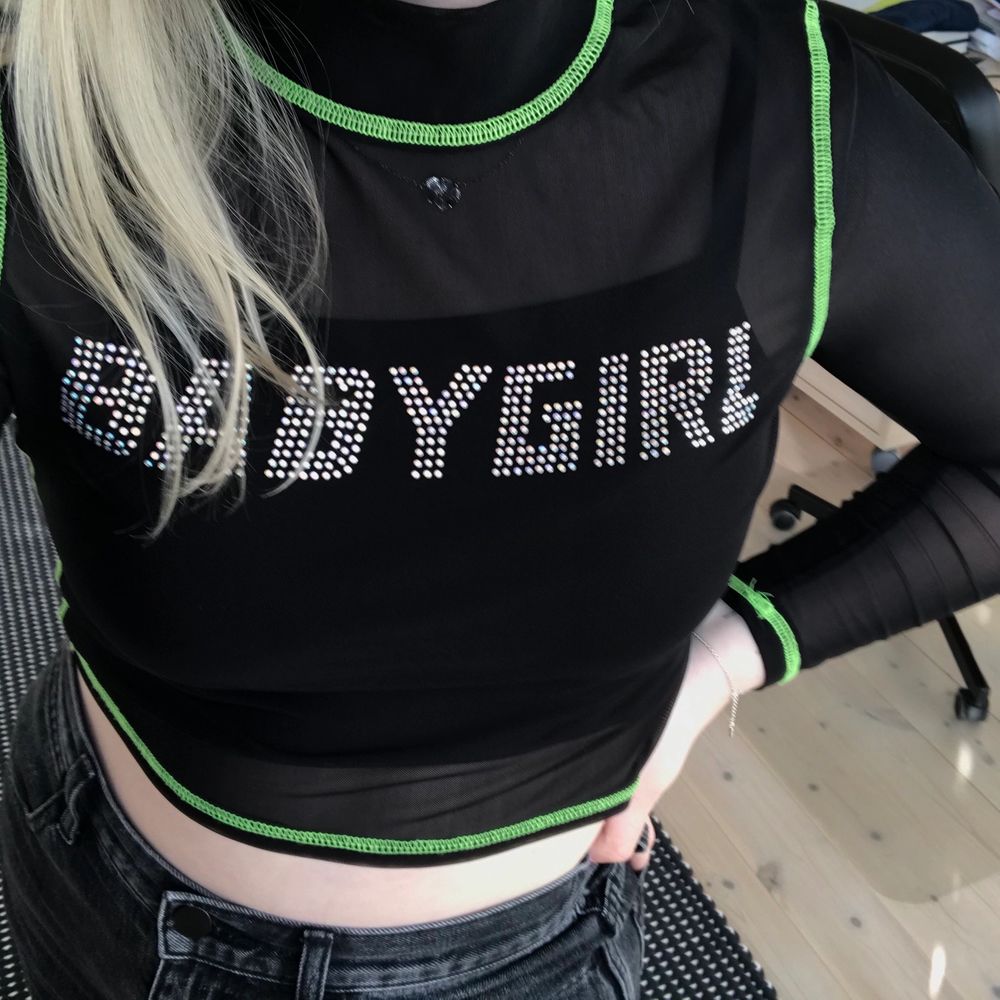 Mesh top med texten ”BABYGIRL” från Urban Outfitters! Gröna neondetaljer längs sömmarna och en kort polo krage. Köpt förra sommaren, jättebra skick. Rekommenderar att ha ett linne under (som på bilden) då den är lite genomskinlig. GRATIS FRAKT💕☺️. Toppar.