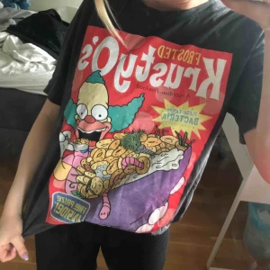  - En ball tröja med motiv från Simpsons. En svartgrå färg och i nyskick. Jag gillar att matcha med en svart läderjacka!🤗