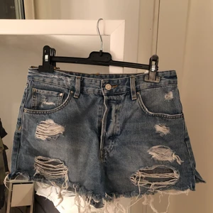 Jeansshorts - Perfekta jeansshorts med så snygga slitningar och 3 knappar. Är tyvärr för små för mig men är i väldigt bra skick fortfarande. Storlek 38.