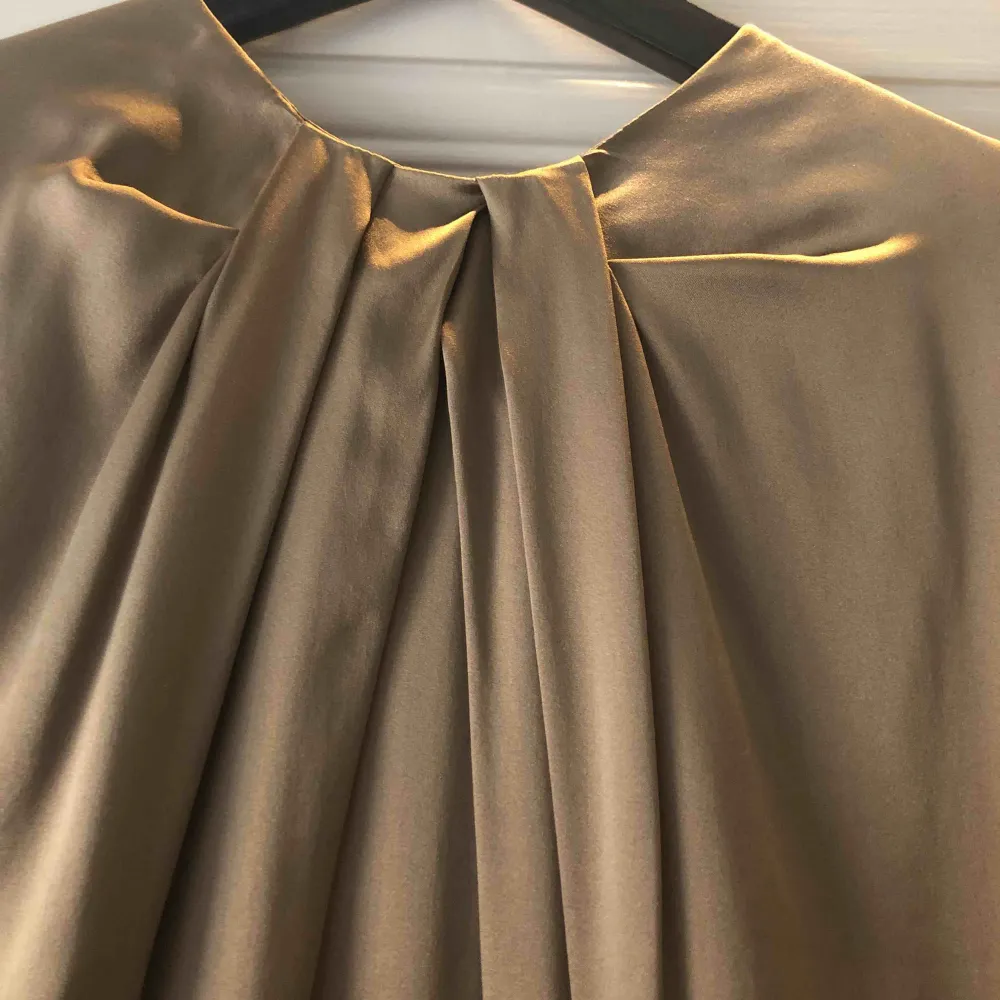 Italiensk sidenklänning. 96%silk 4% elastan. Storleken är italiensk 40 vilket motsvarar S/36. Fråga om du önskar mer beskrivning. Använd 1 gång. Är härligt skimrande i färgen(guld/beige).. Klänningar.