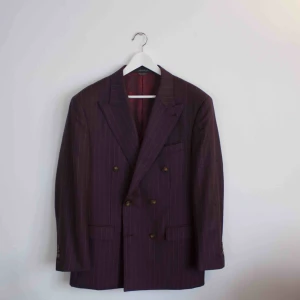  - Säljer en plommon färgad Indochino kostym. Nypris är 800$, jag köpte kostymen på rea för 369$. Det är en dubbelbröstad kostym med vita pinestripes. Kostymen är aldrig använd