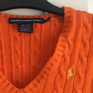  - En kabelstickad tröja från Ralph lauren. Tröjan är orange med gult märke! Den är använd fåtal gånger och i bra skick! Den är i storlek XS  Kontakt: 0732500530(nås på sms) Teamarkholm@gmail.com  Köparen står för frakten 🥰🥰