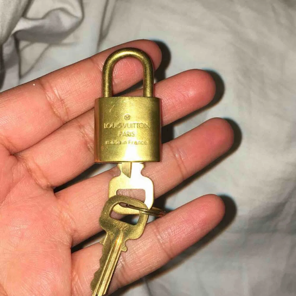 Säljer ett äkta padlock från Louis vuitton. Står nummer 302. Ingår 2 stycken nycklar till. Man kan använda låset till sin Louis vuitton väska eller använda det som ett halsband👌🏽. Accessoarer.