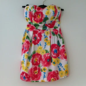 Söt blommig klänning. Kort och utan axelband. Knappt använd. - Söt blommig klänning. Kort och utan axelband. Knappt använd.