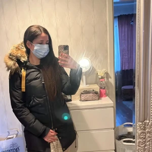 Svart Parajumper longbear med päls som ny! - Säljer en svart Parajumper long bear med stor fluffig päls på huvan och gul detalj vid halsen. Jackan har dragkedja framtill och patch på ärmen. Perfekt för kalla dagar och har en riktigt snygg streetstil. I perfekt skick!