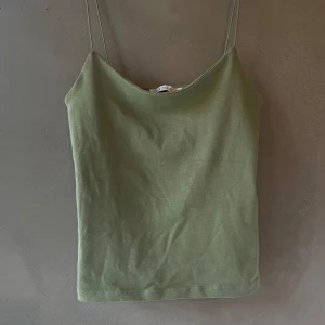 Militärgrönt linne från Zara - Ett militärgrönt linne från Zara i M som jag aldrig använder och därför säljer. I bra skick och dubbelvikt tyg vid bysten. 