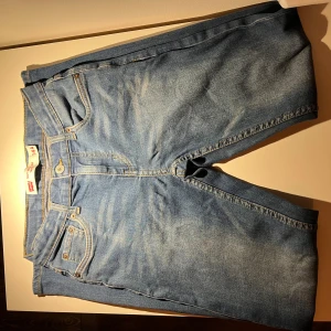 Levi's 502 Regular Taper jeans ljusblå - Ljusblå Levi's 502 Regular Taper jeans med klassisk femficksdesign, gul kontrastsöm och knappgylf. Jeansen har en avsmalnande passform och är tillverkade i mjukt denimtyg. Perfekta för en avslappnad och trendig look.