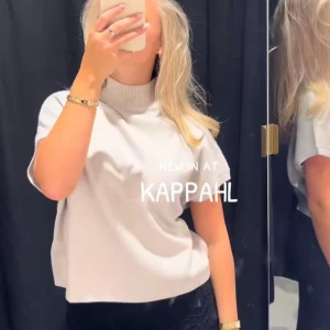 Vit polotröja från Kappahl - Säljer en stilren vit polotröja från Kappahl med korta ärmar och hög ribbad krage. Tröjan har en rak, något boxig passform och är perfekt för lager-på-lager. Enkel att matcha och superfräsch till både jeans och kjol.