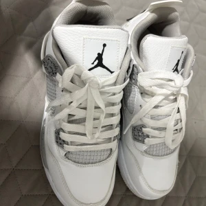 Nike Air Jordan 4 White Oreo sneakers (akopia) - (CREASE SKYDD INGÅR).   Säljer ett par Nike Air Jordan 4 White Oreo sneakers i vitt och coola detaljer och klassisk Jumpman-logga. Skorna har snörning, meshpaneler och stänkmönstrade gråa inslag på sula och öglor Det är använd 1 gång! 